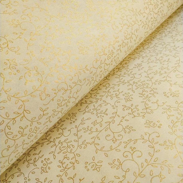A close-up of Kozo Studio mulberry paper showing a refined gold vine and leaf pattern on luxurious ivory handmade paper.
