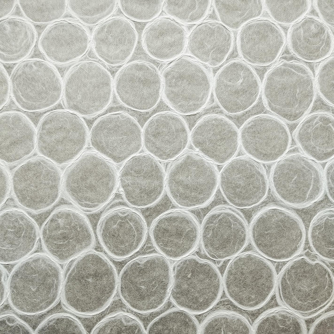 A detailed view of handmade mulberry paper from Kozo Studio showing a mosaic of soft, bubble-like circles on a translucent surface, perfect for artistic uses.
