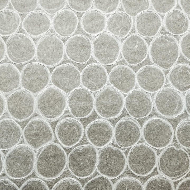 A detailed view of handmade mulberry paper from Kozo Studio showing a mosaic of soft, bubble-like circles on a translucent surface, perfect for artistic uses.