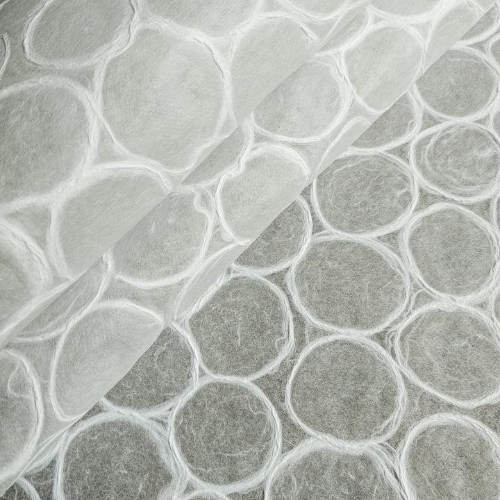Close-up of Kozo Studio handmade paper featuring translucent circular textures reminiscent of bubble wrap, showcasing the delicate fiber patterns typical of mulberry paper.