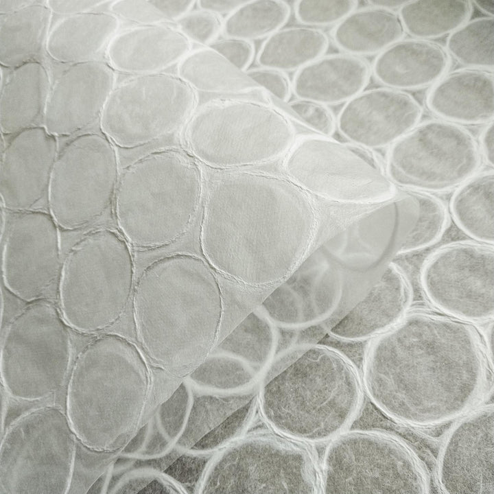 Artistic detail of Kozo Studio mulberry paper with an abstract pattern of round shapes and fine fibers, suitable for decorative and functional handmade paper crafts.