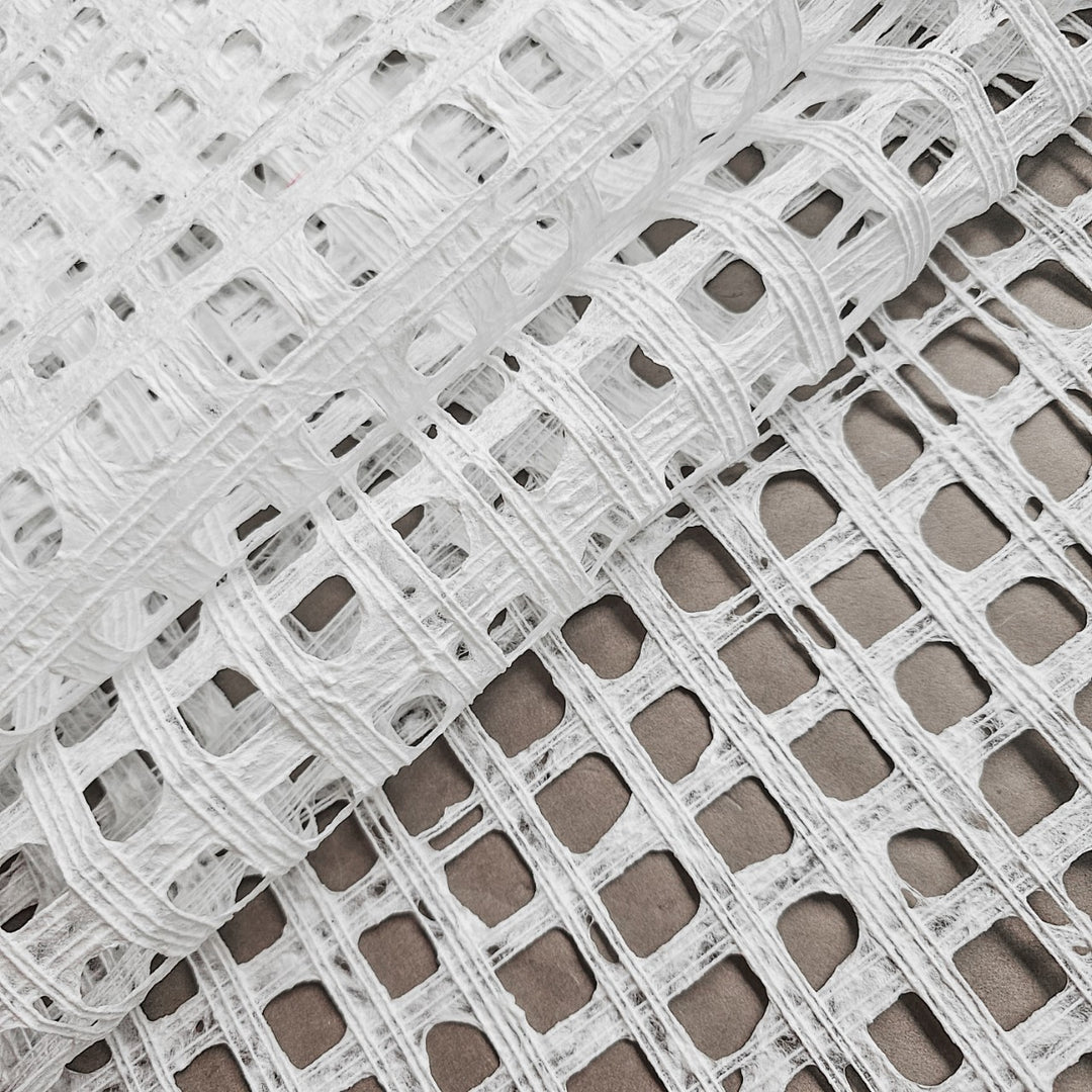 Close-up of white mulberry paper created at Kozo Studio, showcasing intricate cotton thread lines woven into the handmade paper surface.