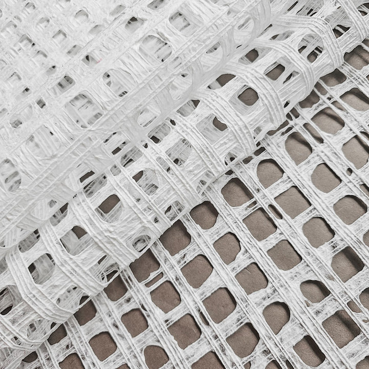 Close-up of white mulberry paper created at Kozo Studio, showcasing intricate cotton thread lines woven into the handmade paper surface.