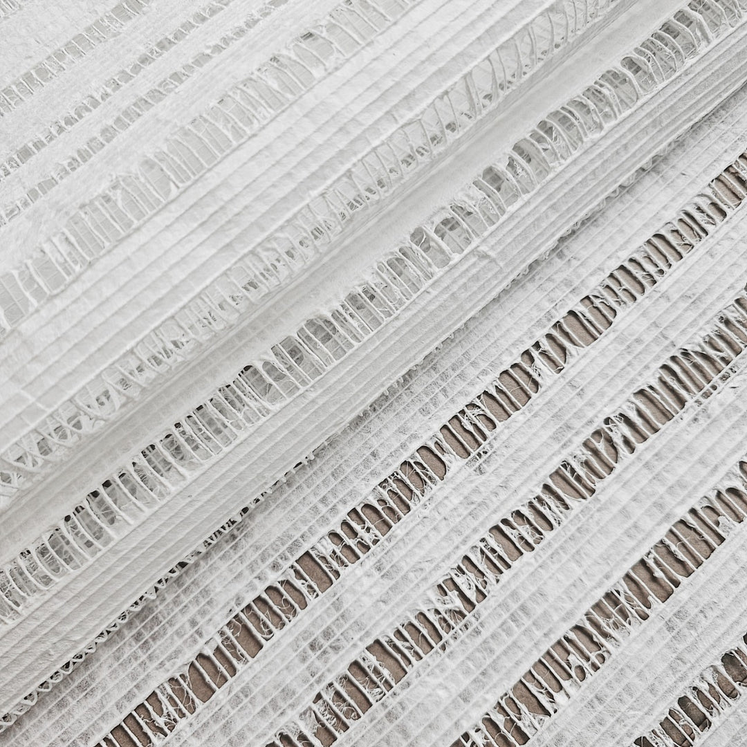Close-up of Handmade Geloma Kozo Paper (White) from Kozo Studio, featuring white textured fabric with horizontal openwork stripes and thin vertical grid lines like delicate rice paper. Lightweight and slightly sheer, this airy pattern adds elegance to any setting.