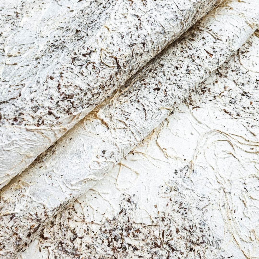Textured handmade mulberry paper from Kozo Studio, showcasing a rough surface and earthy two-tone colors ideal for mixed media and collage projects.