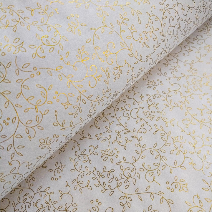 A roll of handmade paper from Kozo Studio featuring a gold grapevine pattern on soft white mulberry paper, perfect for elegant art and design projects.