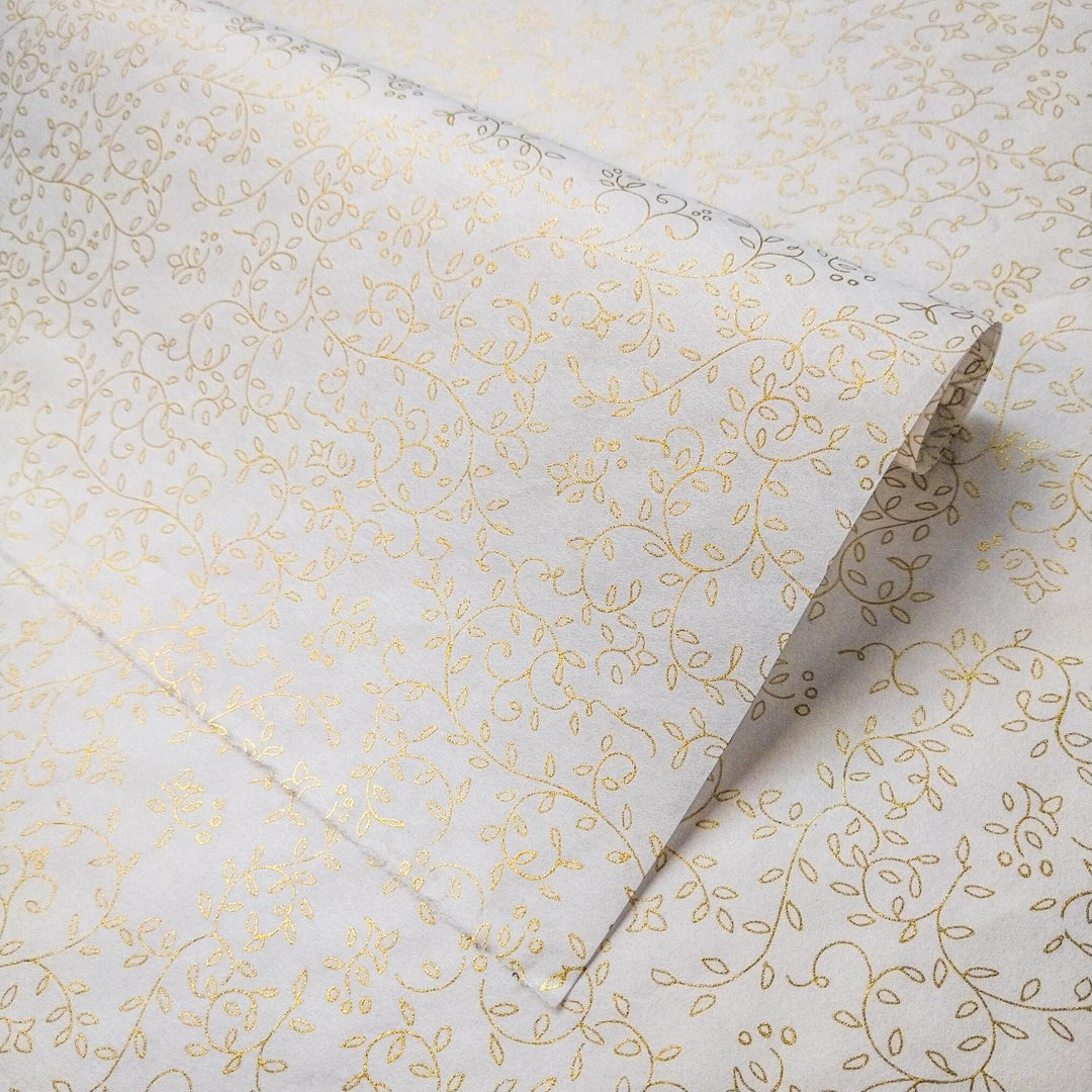 Unrolled sheet of Grapevine Screen-printed handmade paper from Kozo Studio featuring a gold floral design on white mulberry paper with elegant vines and leaves.
