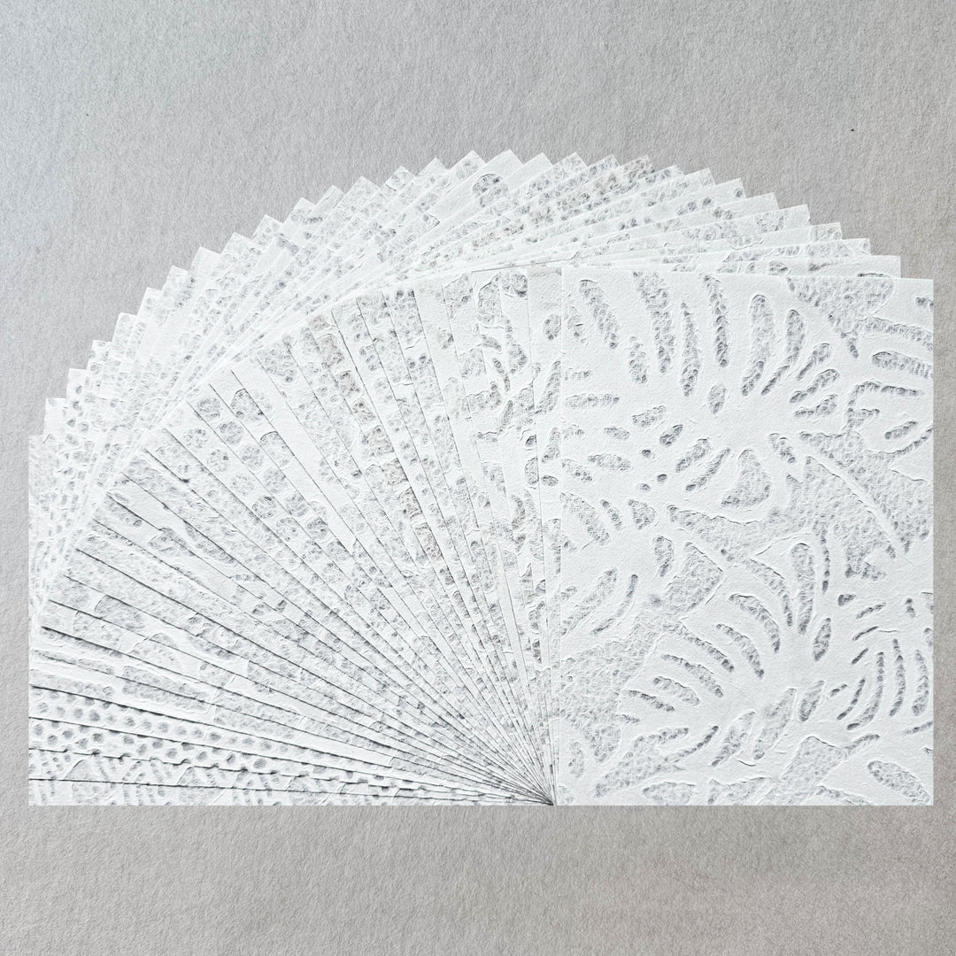 Handmade lace mulberry paper pack from Kozo Studio featuring 15 intricate Rakusui designs, ideal for crafts, collages, and invitations.