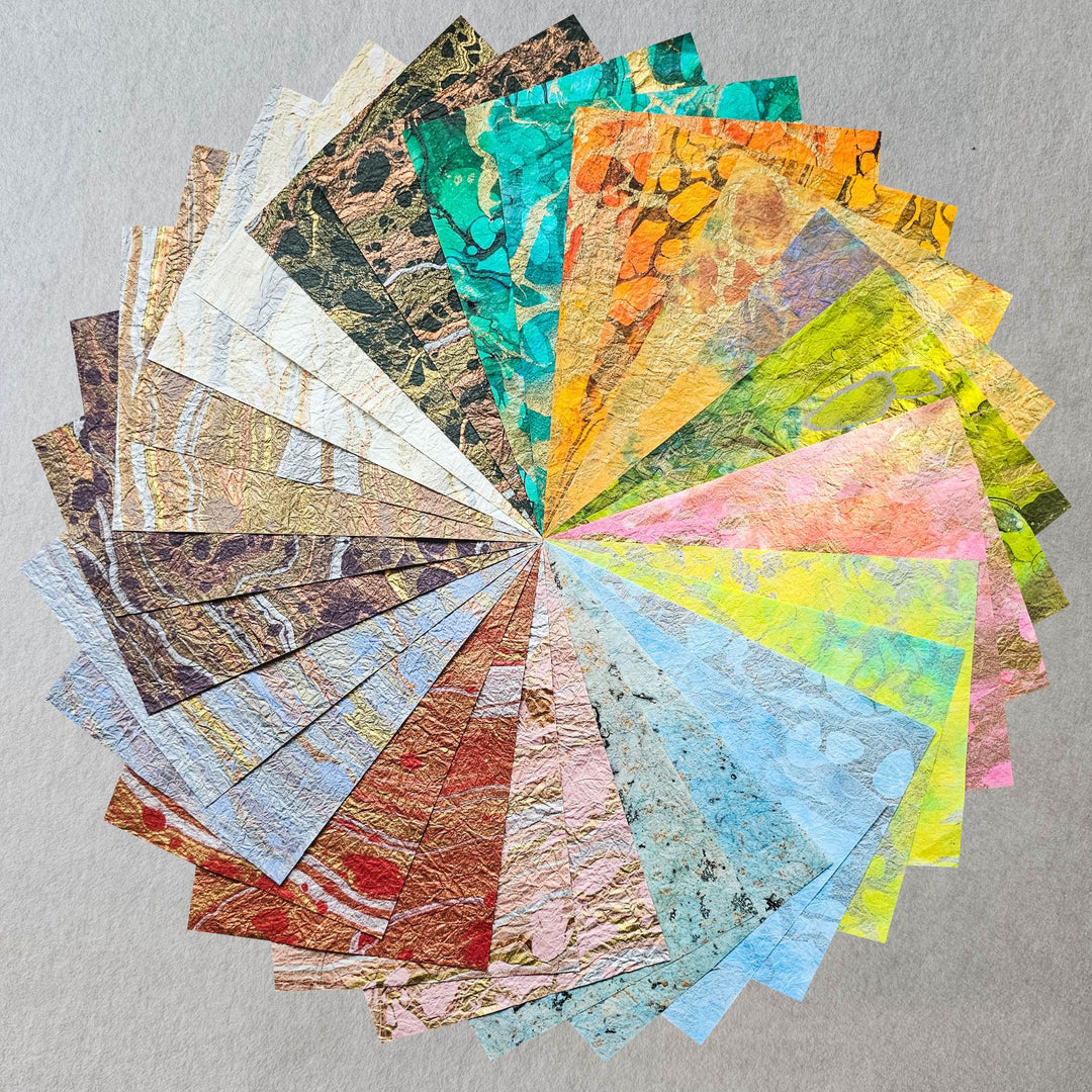 A colorful collection of 30 sheets of handmade mulberry paper from Kozo Studio with rich oil-marbled designs, perfect for crafts, journaling, and decorative art.