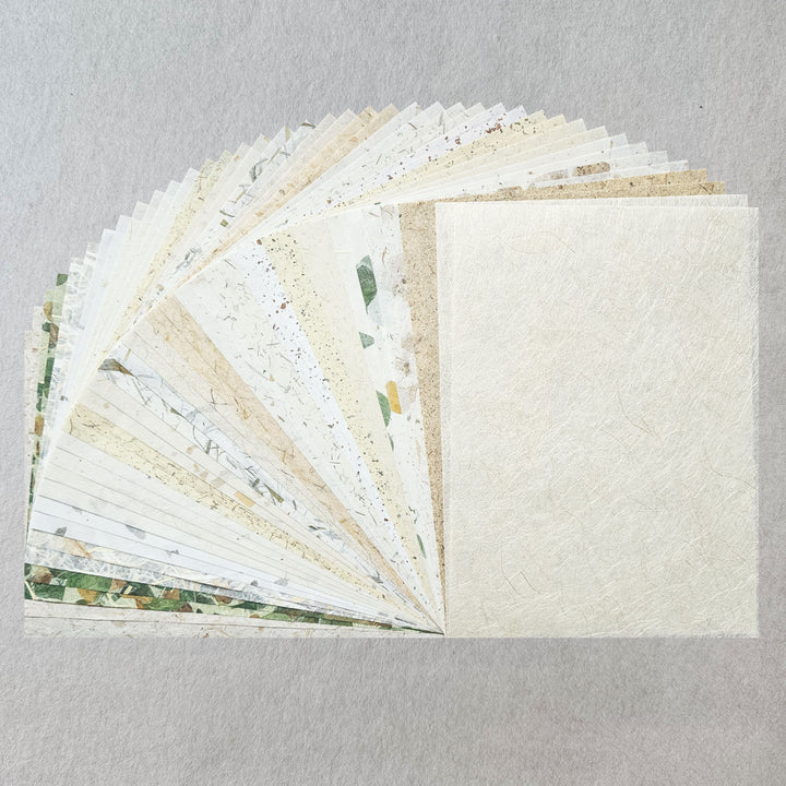 A vibrant assortment of 40 handmade paper sheets from Kozo Studio, featuring specialty mulberry paper made from kozo pulp and natural foliage like banana fiber, bamboo leaf, and mango leaf.