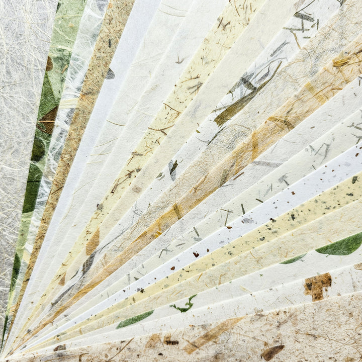 Artistic selection of handmade mulberry papers from Kozo Studio, highlighting the fibrous textures and natural tones of kozo-based paper varieties ideal for scrapbooking, card-making, and crafts