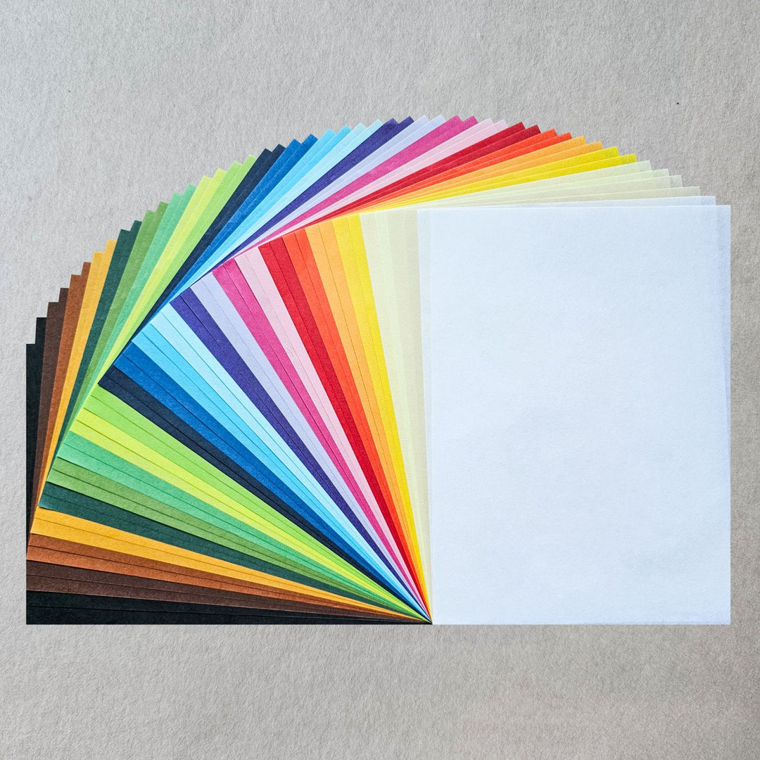 Close-up of a 48-sheet pack of solid-colored handmade paper from Kozo Studio, featuring 24 vibrant hues of lightweight mulberry paper perfect for origami, printmaking, and other papercraft projects.