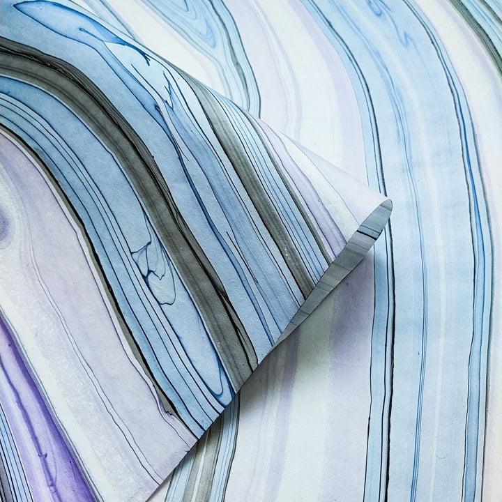 Kozo Studio Marble Kozo Paper Design 2 featuring swirling oil marbling on mulberry paper with lifted corner revealing layered handmade paper texture.