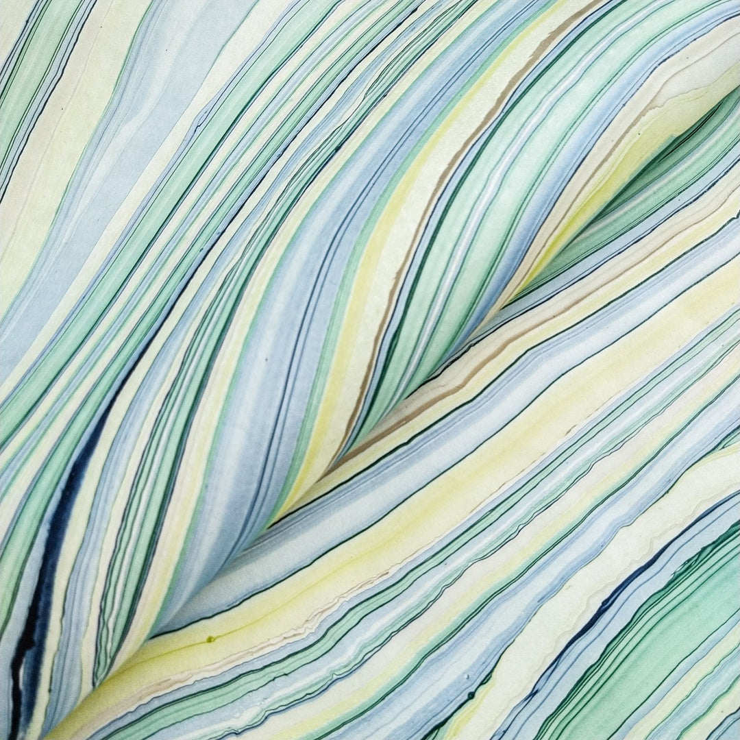 Colorful close-up of swirling oil patterns on mulberry paper from Kozo Studio. This handmade paper in Marble Design 3 features rippled textures and a fluid geometric look in natural tones.