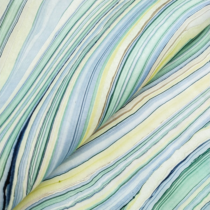 Colorful close-up of swirling oil patterns on mulberry paper from Kozo Studio. This handmade paper in Marble Design 3 features rippled textures and a fluid geometric look in natural tones.