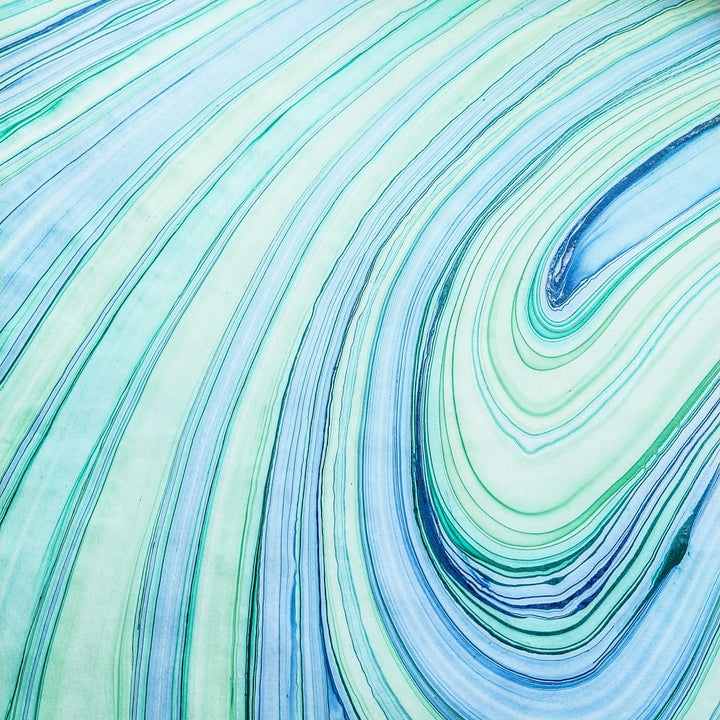 Artistic view of Marble Kozo handmade paper with turquoise and green swirls, crafted at Kozo Studio using traditional mulberry paper methods.