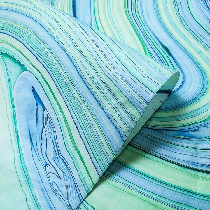 Swirling marble pattern on handmade mulberry paper by Kozo Studio, highlighting the unique texture and artistic process of Marble Kozo Paper.