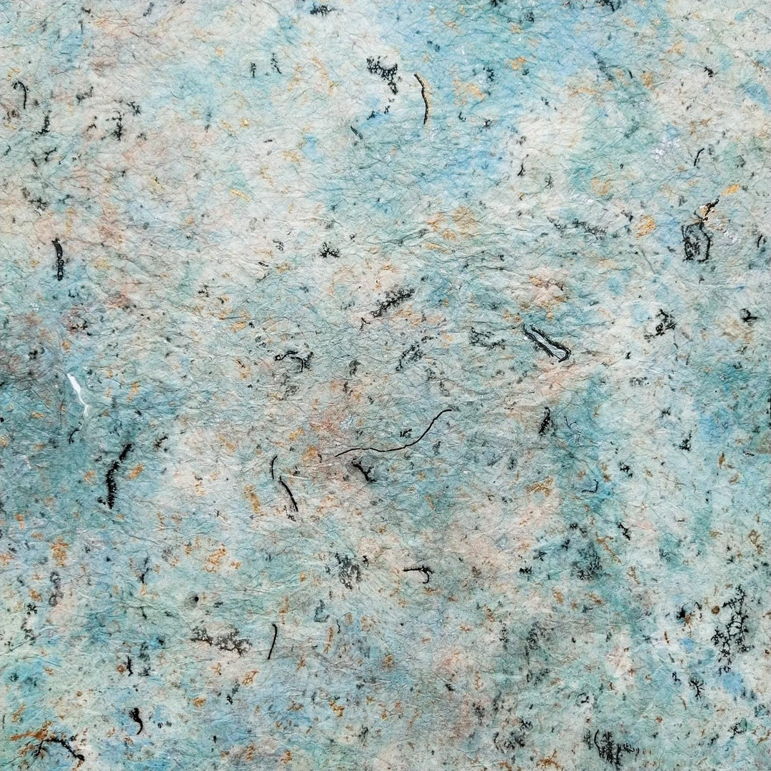 Milano Kozo Paper - Design 1 by Kozo Studio features an abstract texture with a mix of light blue, white, subtle orange hints, and scattered black squiggly lines. The design creates a marbled, mulberry paper effect with a soft, fibrous look.