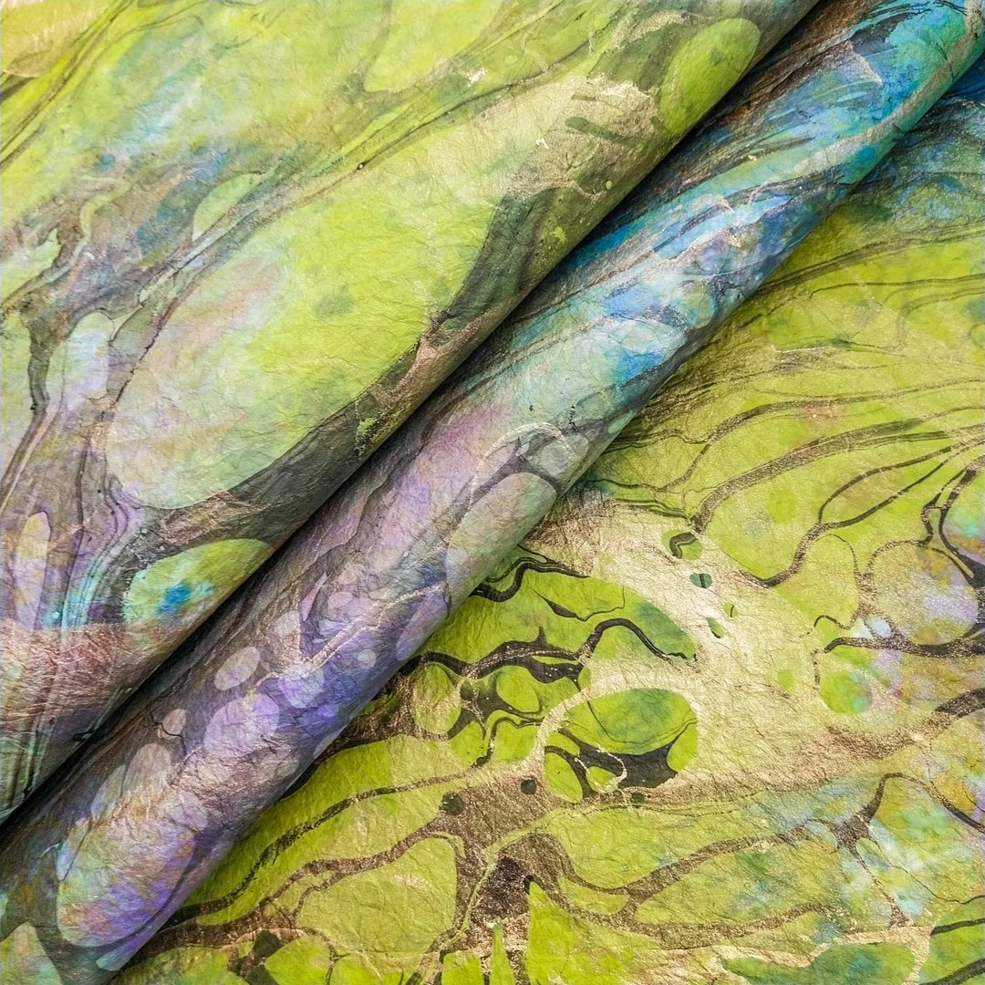 Abstract marbled artwork on handmade mulberry paper by Kozo Studio, featuring green, yellow, and blue swirls with a textured landscape effect.