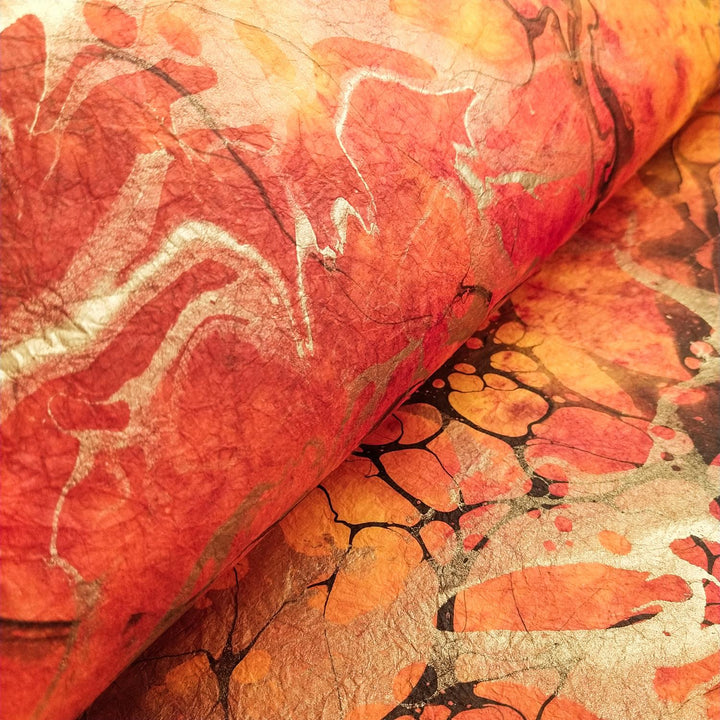 Fiery orange and gold swirls flow across Milano Kozo Paper Design 7, a handmade paper from Kozo Studio, emphasizing its rich color and soft texture.