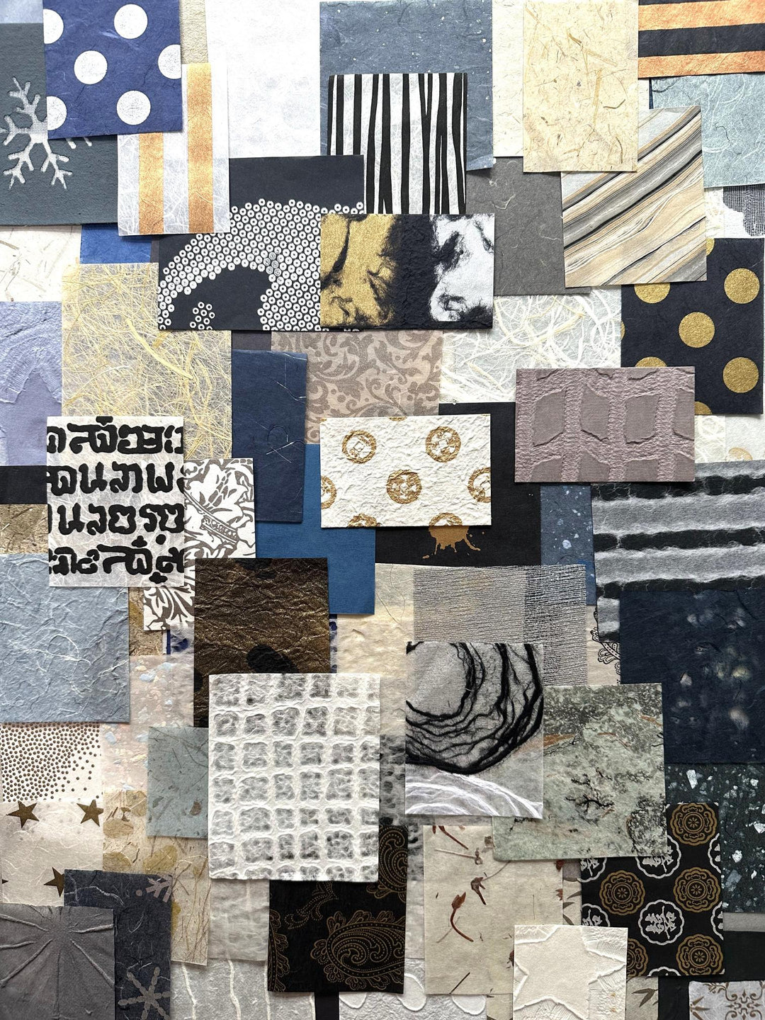 A 100-piece mulberry paper scrap pack from Kozo Studio, showcasing handmade paper in blue, white, and gold tones. Each unique design offers inspiration for scrapbooking, collaging, or creative crafts.