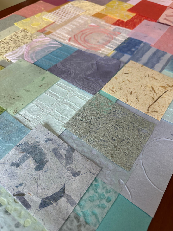 Artfully arranged Kozo Studio handmade mulberry paper scrap pack with 100 pastel-colored pieces in various sizes, ideal for mixed media and craft lovers.