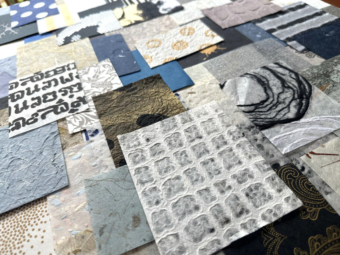 The Kozo Studio Mulberry Paper Scrap Pack (100 Pieces) - Winter Solace includes a collage of assorted textured paper squares with patterns, unfamiliar script, abstract art, rice paper in gray, blue, and beige shades, plus mulberry papers featuring metallic elements.