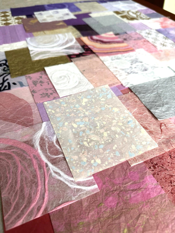 Artistic flat lay of Kozo Studio’s handmade mulberry paper pack, a curated 100-piece set with pink, purple, and white shades, ideal for collage, scrapbooking, and other DIY crafts.