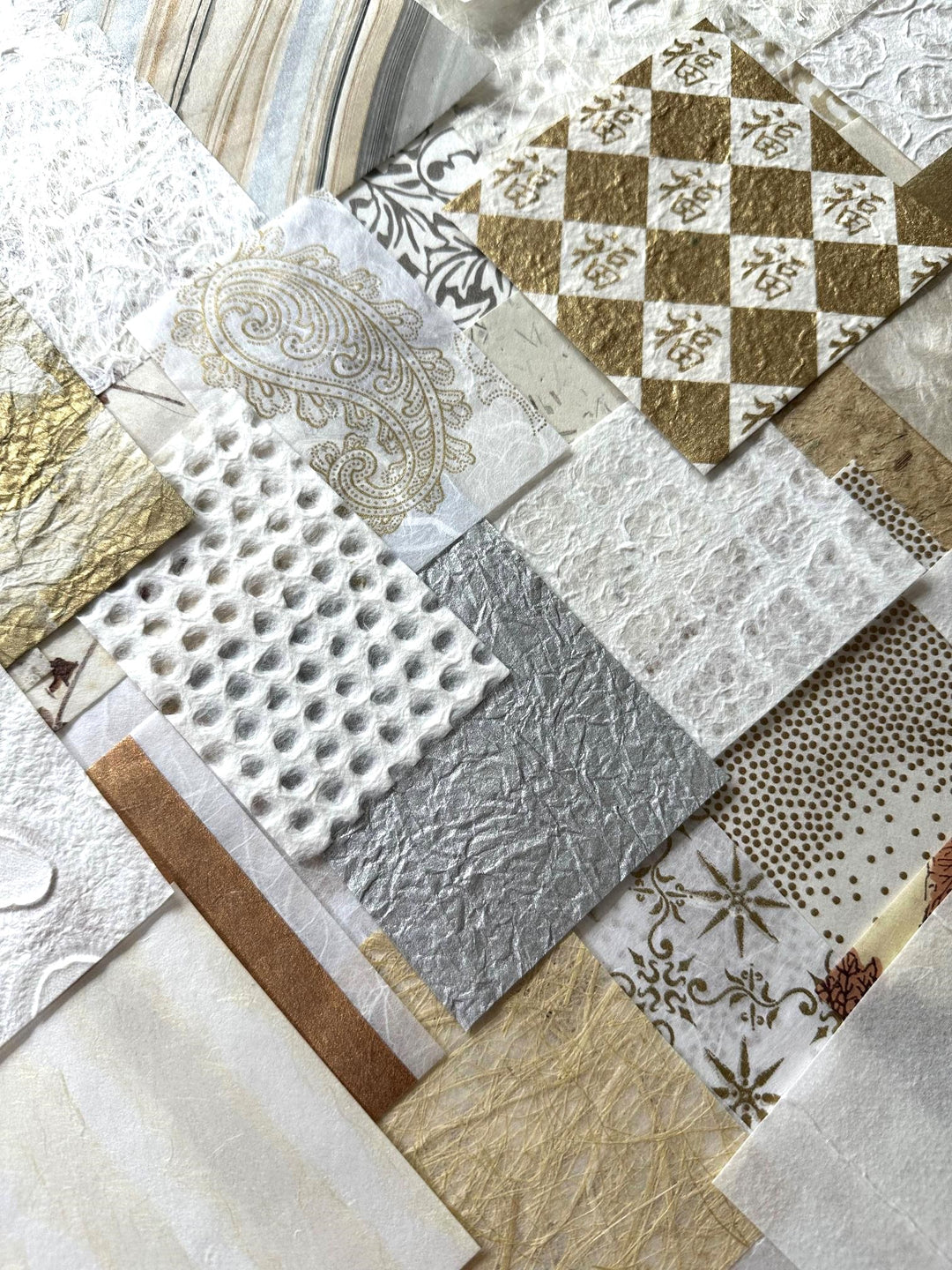 A creative assortment of Kozo Studio's handmade mulberry paper pack, with a mix of natural white and gold paper pieces, curated for collage, journaling, and artistic projects.