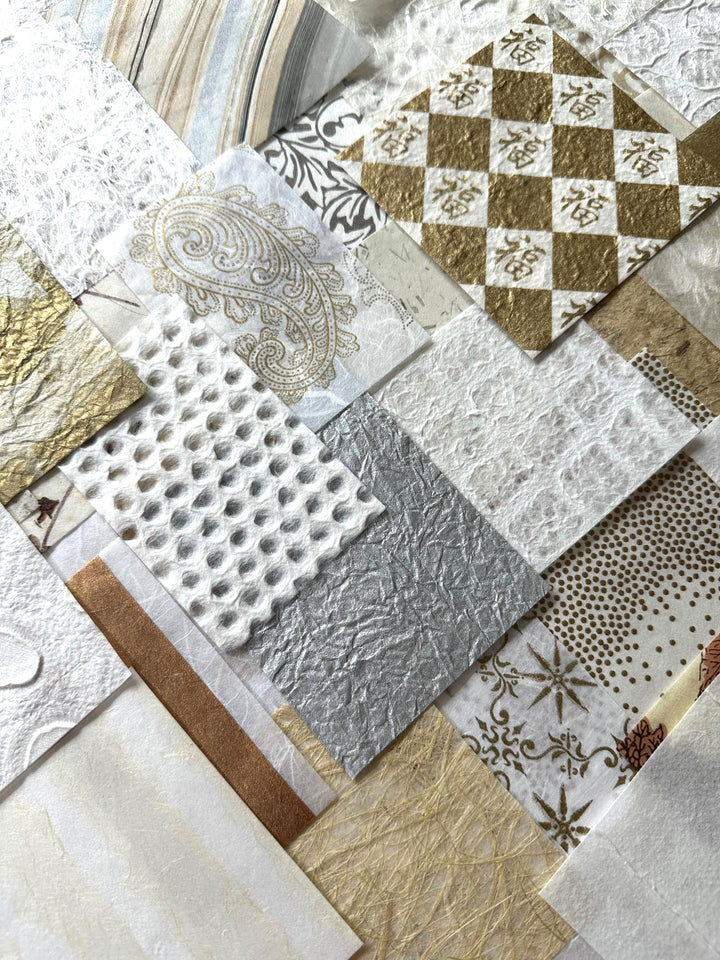 A creative assortment of Kozo Studio's handmade mulberry paper pack, with a mix of natural white and gold paper pieces, curated for collage, journaling, and artistic projects.