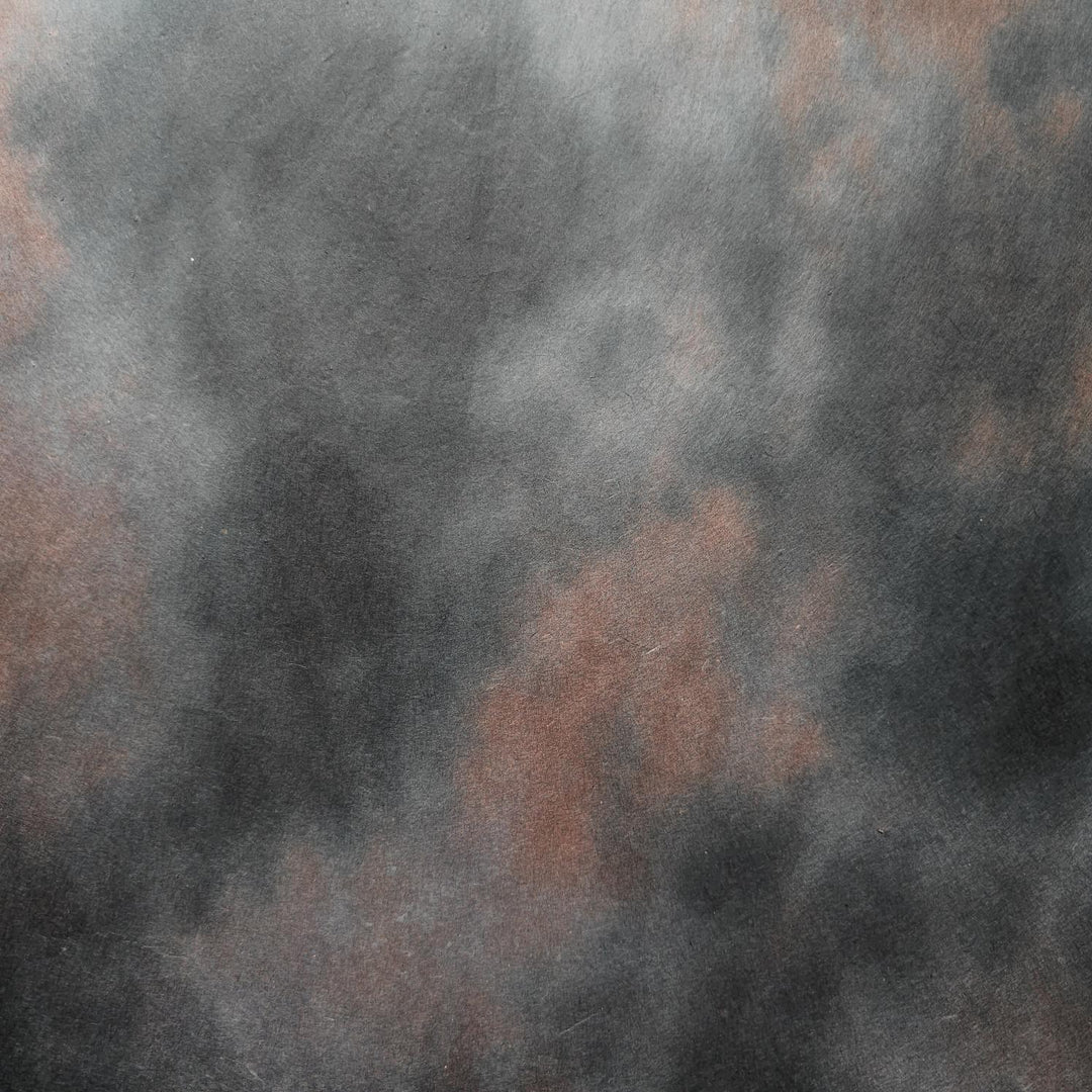 A gradient blend of dark tones in Kozo Studio's Ombre handmade paper made from mulberry pulp, highlighting the unique smoky effect and natural texture of artisanal paper.