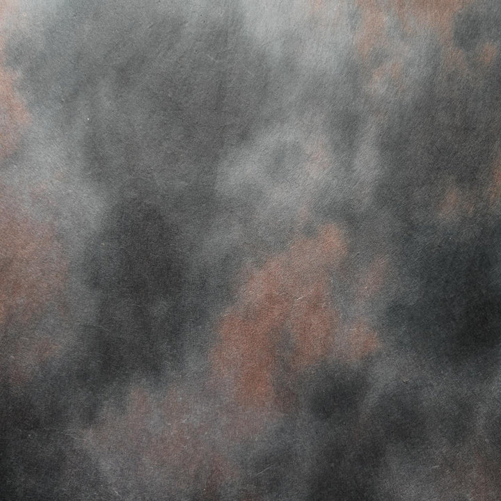 A gradient blend of dark tones in Kozo Studio's Ombre handmade paper made from mulberry pulp, highlighting the unique smoky effect and natural texture of artisanal paper.