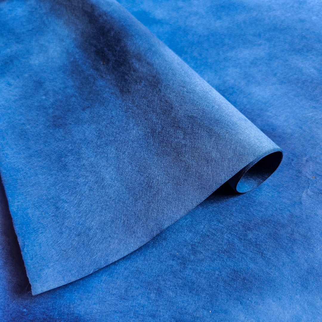 Gradient blue handmade paper sheet by Kozo Studio, made from soft yet durable mulberry paper, featuring slight natural texture from artisanal coloring techniques.