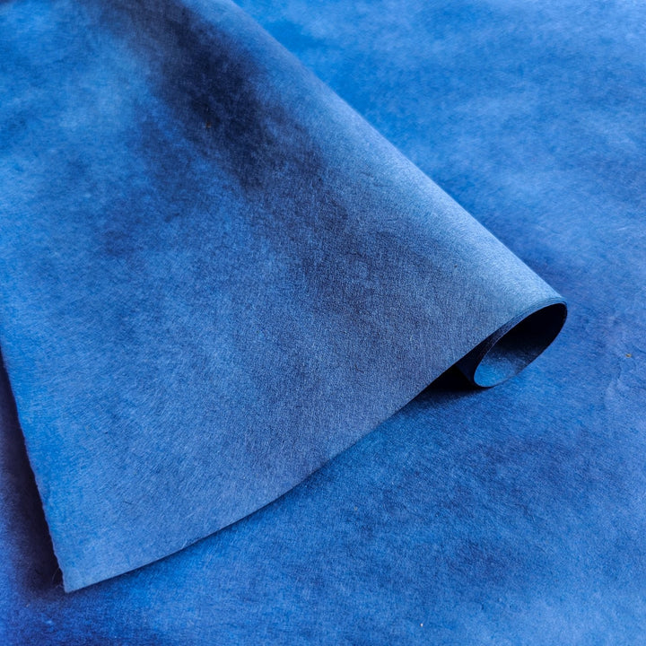 Gradient blue handmade paper sheet by Kozo Studio, made from soft yet durable mulberry paper, featuring slight natural texture from artisanal coloring techniques.