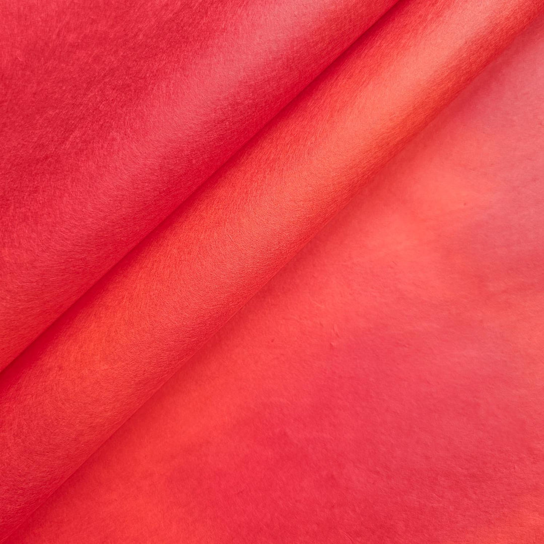 Vibrant handmade paper from Kozo Studio, featuring a smooth ombre gradient in red tones; this mulberry paper is hand-colored for a stunning visual impact.