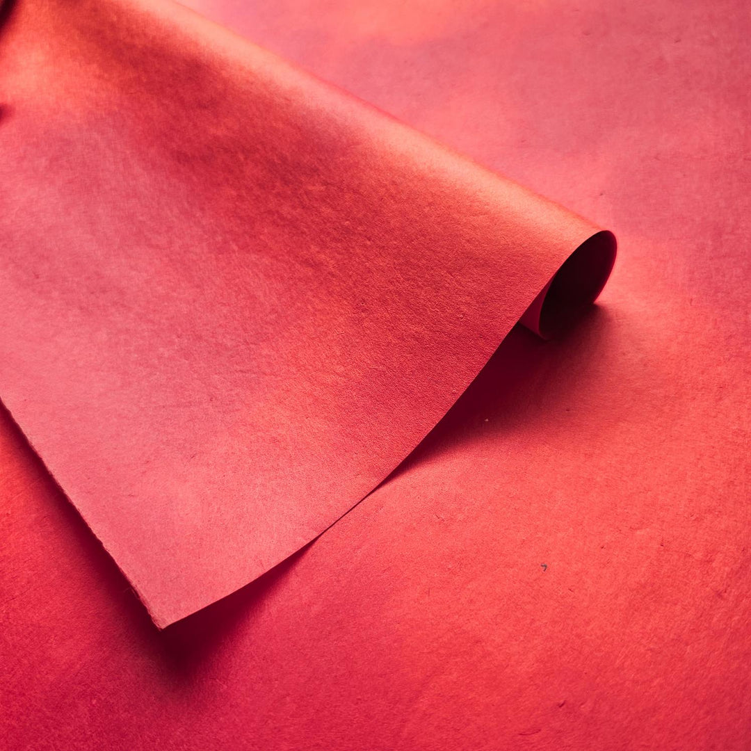 Red ombre mulberry paper by Kozo Studio, crafted by hand with a seamless blend of hues and a soft texture ideal for artistic and decorative projects.
