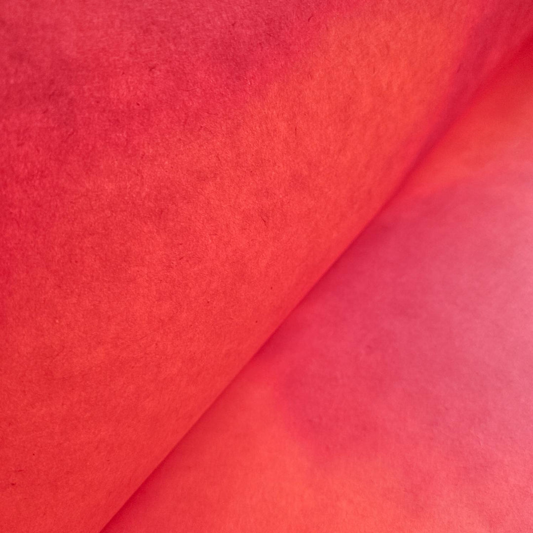 Textured surface of Kozo Studio handmade paper in ombre red shades; premium mulberry paper perfect for crafts, art, and design.