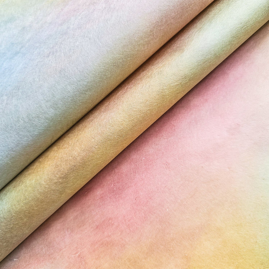 Close-up of Ombre handmade paper rolls from Kozo Studio featuring pastel gradients of yellow, pink, and peach, showcasing the soft texture and premium quality of mulberry paper.