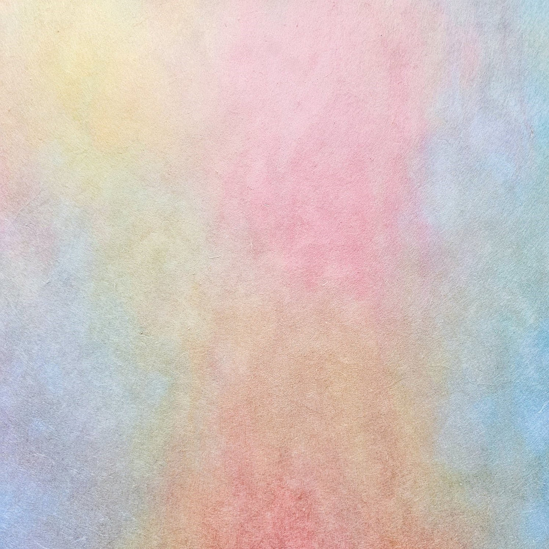 Elegant Kozo Studio handmade paper rolls in ombre tones of pink, peach, and yellow, crafted from premium mulberry paper perfect for creative projects and design accents.