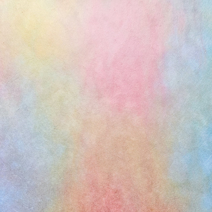 Elegant Kozo Studio handmade paper rolls in ombre tones of pink, peach, and yellow, crafted from premium mulberry paper perfect for creative projects and design accents.