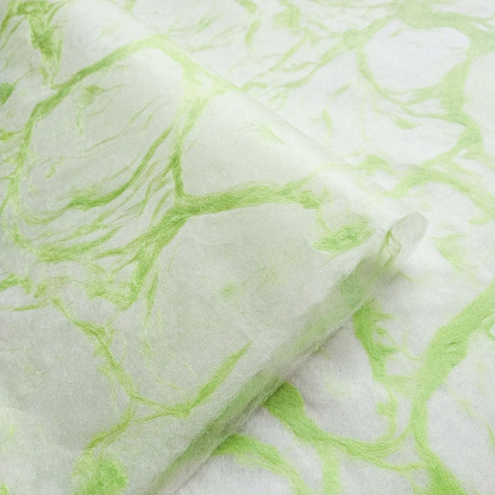 Kozo Studio's handcrafted Ripple Kozo Paper in green on white, highlighting the lightweight quality and swirling green patterns of mulberry paper.