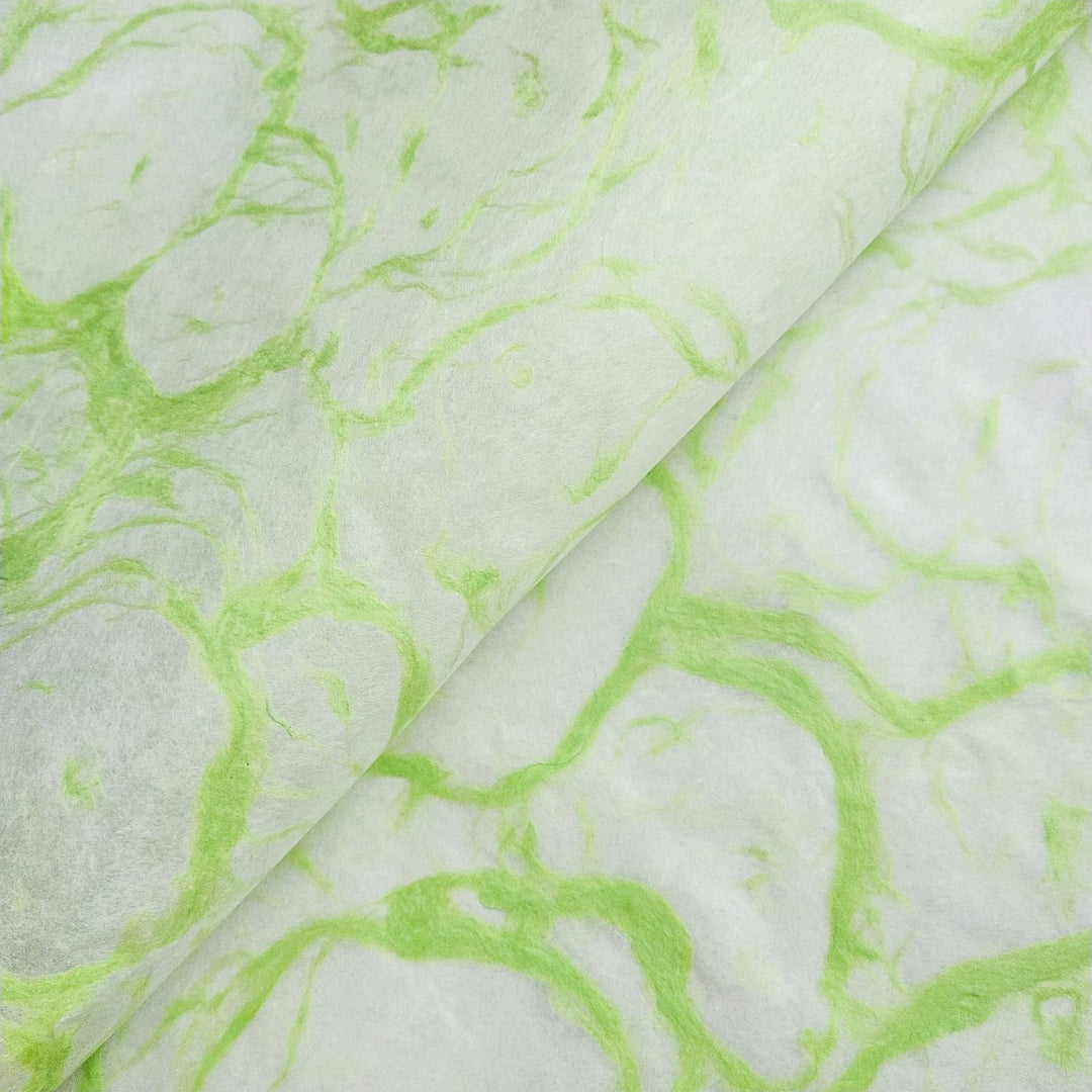 Close-up of translucent white mulberry paper with green marble-like swirls from Kozo Studio's Ripple Kozo Paper collection, showcasing handmade paper texture and detail.
