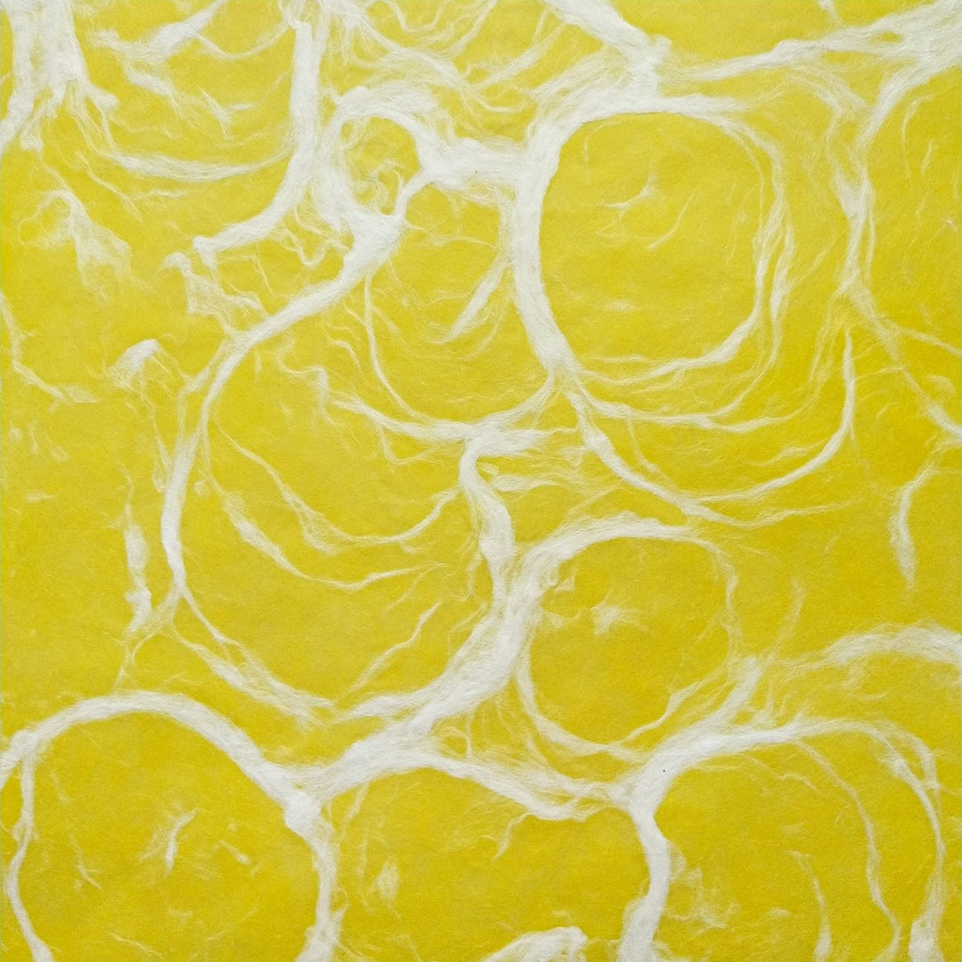 Ripple Kozo paper by Kozo Studio in white on yellow, highlighting the delicate texture of handmade mulberry paper with swirling fibers.