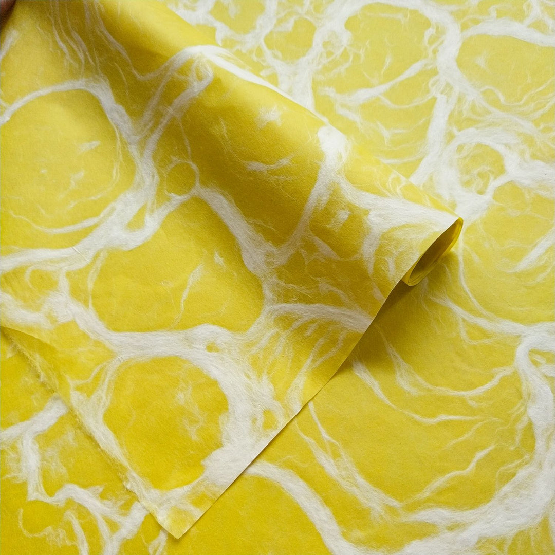 Handmade mulberry paper in Ripple Kozo style by Kozo Studio, displaying intricate white swirls over a bold yellow background