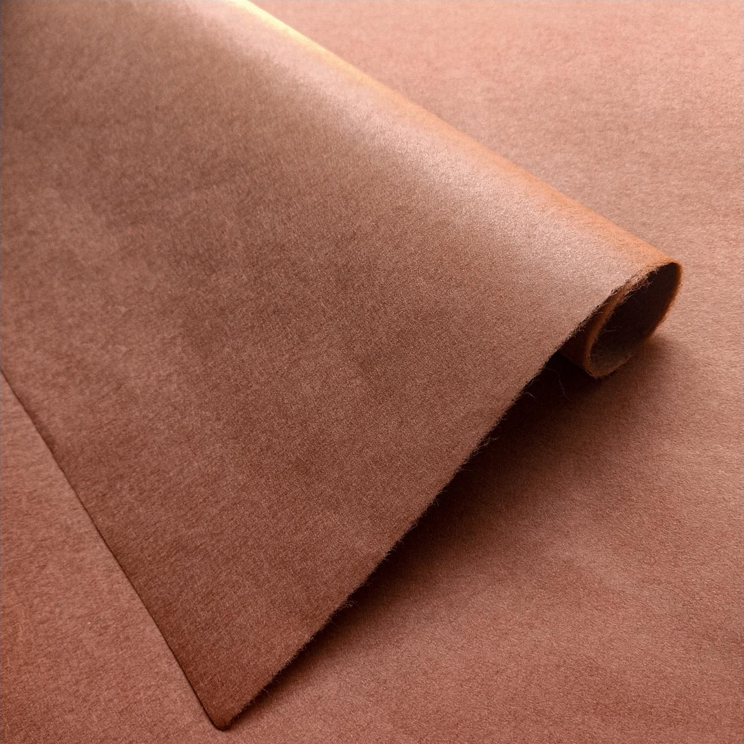 Amber brown handmade paper sheets from Kozo Studio, made with fine mulberry fibers and showcasing a smooth texture with subtle sheen.