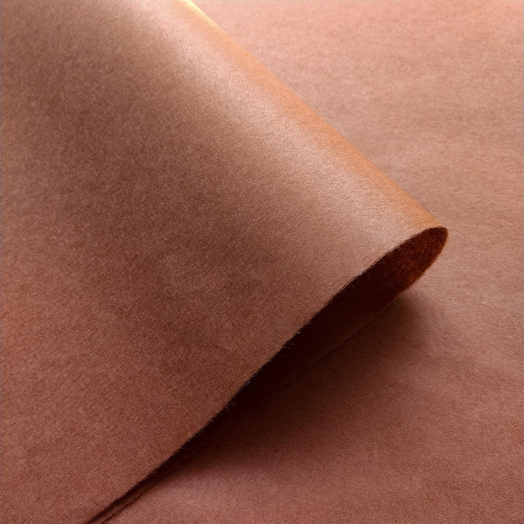 Stack of smooth amber brown handmade mulberry paper from Kozo Studio, perfect for elegant and minimalist creative projects.