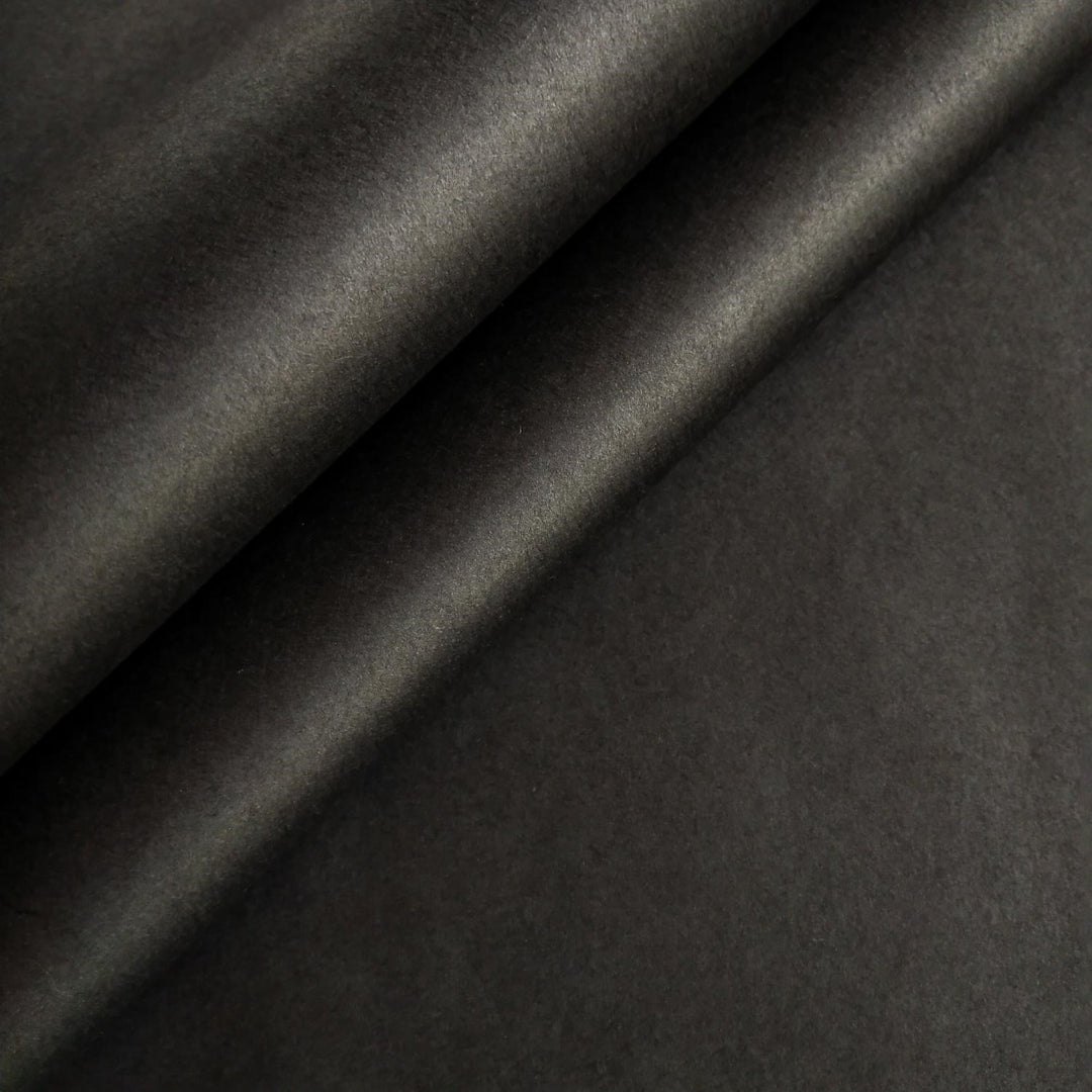 Close-up of black handmade mulberry paper by Kozo Studio showing smooth texture and natural folds.