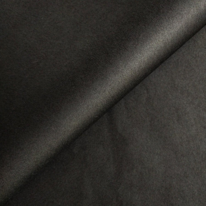 Close-up texture of black mulberry paper crafted by Kozo Studio with visible handmade paper creases and depth.