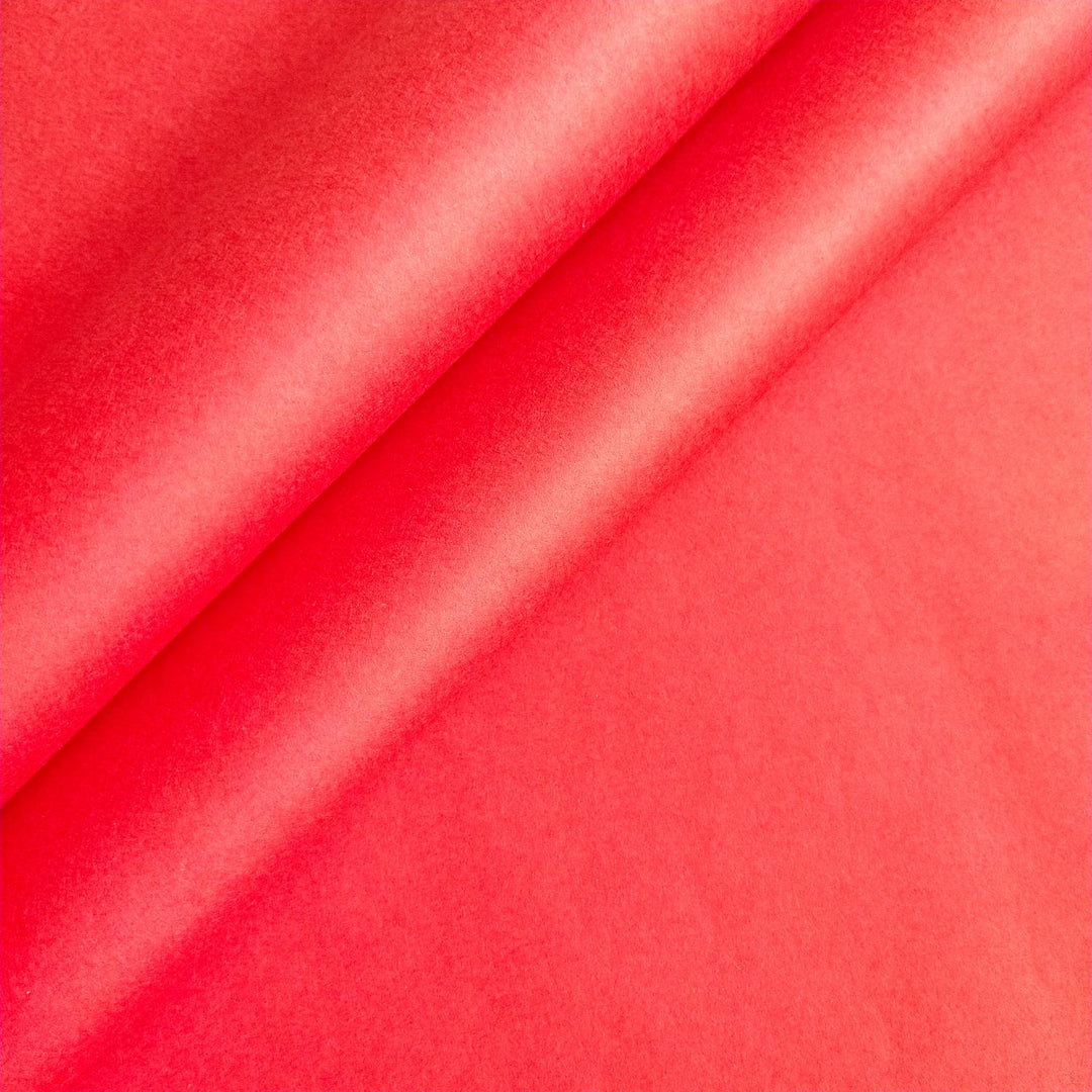 Close-up of cherry red mulberry paper from Kozo Studio, showcasing the soft texture and gentle creases of handmade paper.