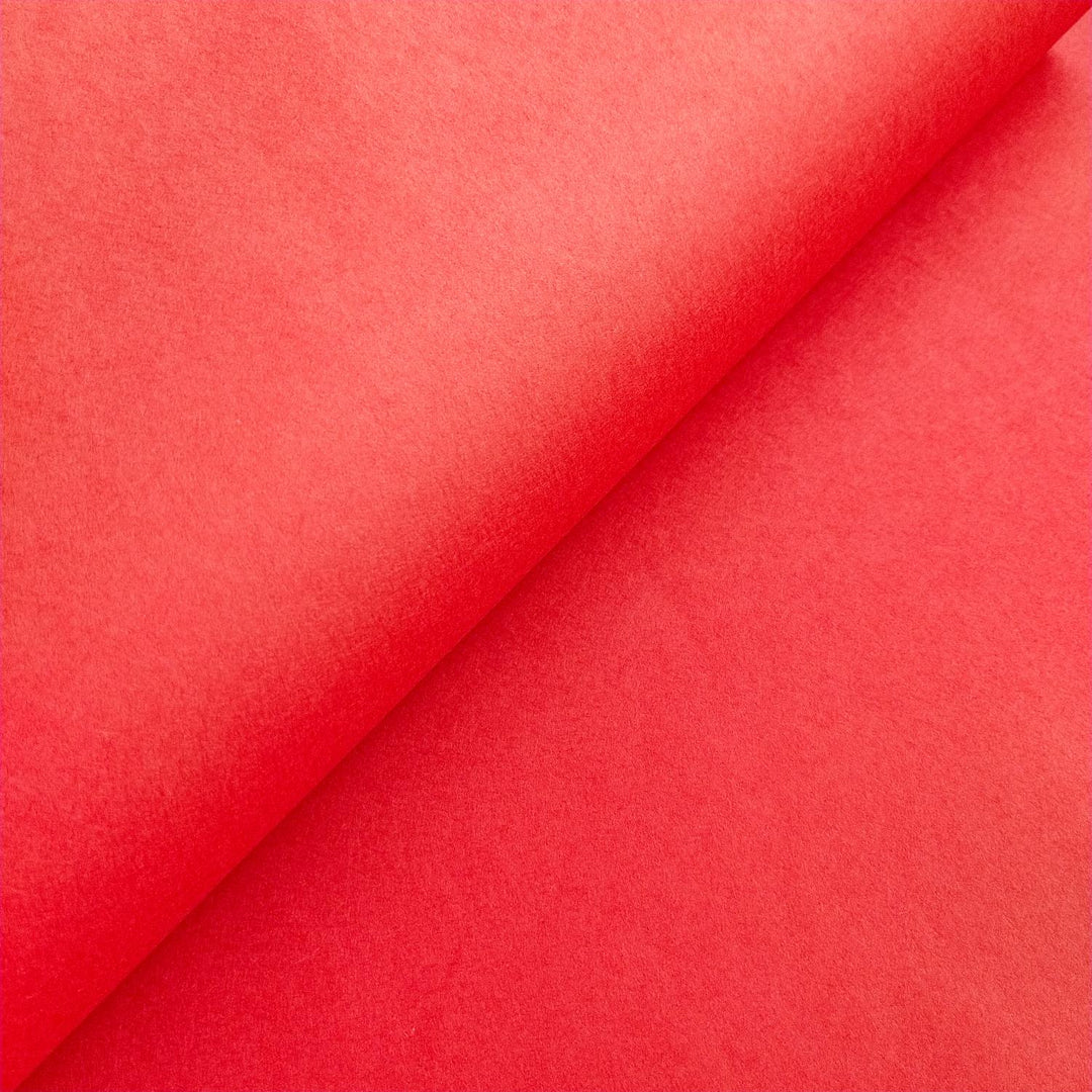 High-resolution image of Kozo Studio cherry red handmade mulberry paper, showing subtle shadows and a soft, fibrous texture.